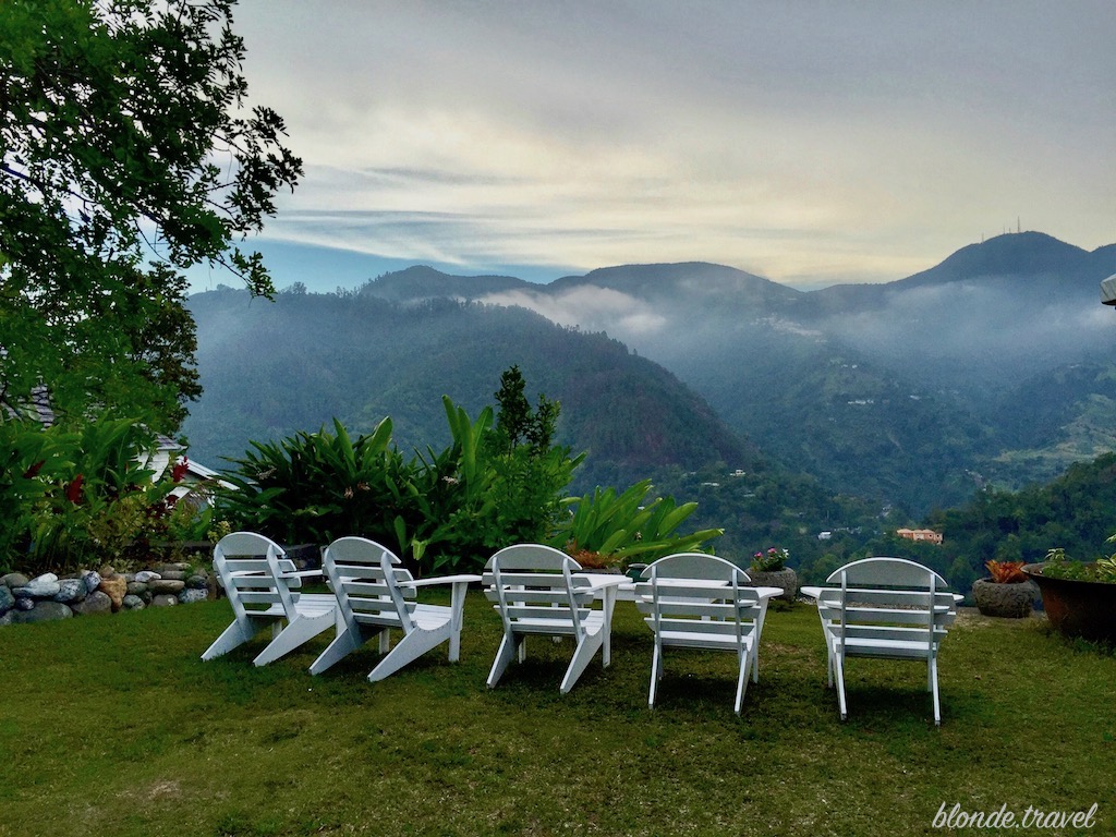 White wooden chairs facing misty Blue Mountain ridges