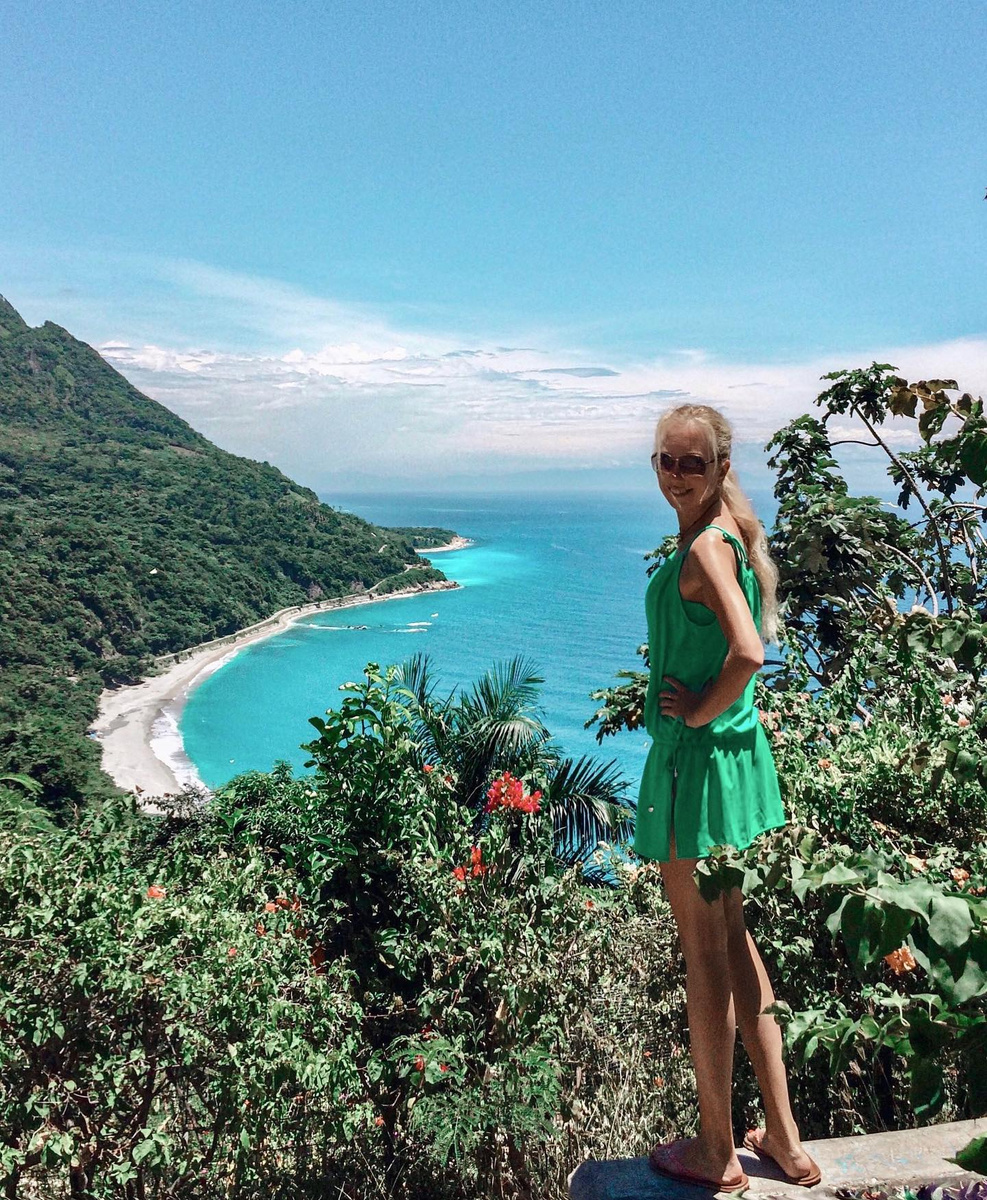 Olga above a green Dominican coastline curving around bright blue water.