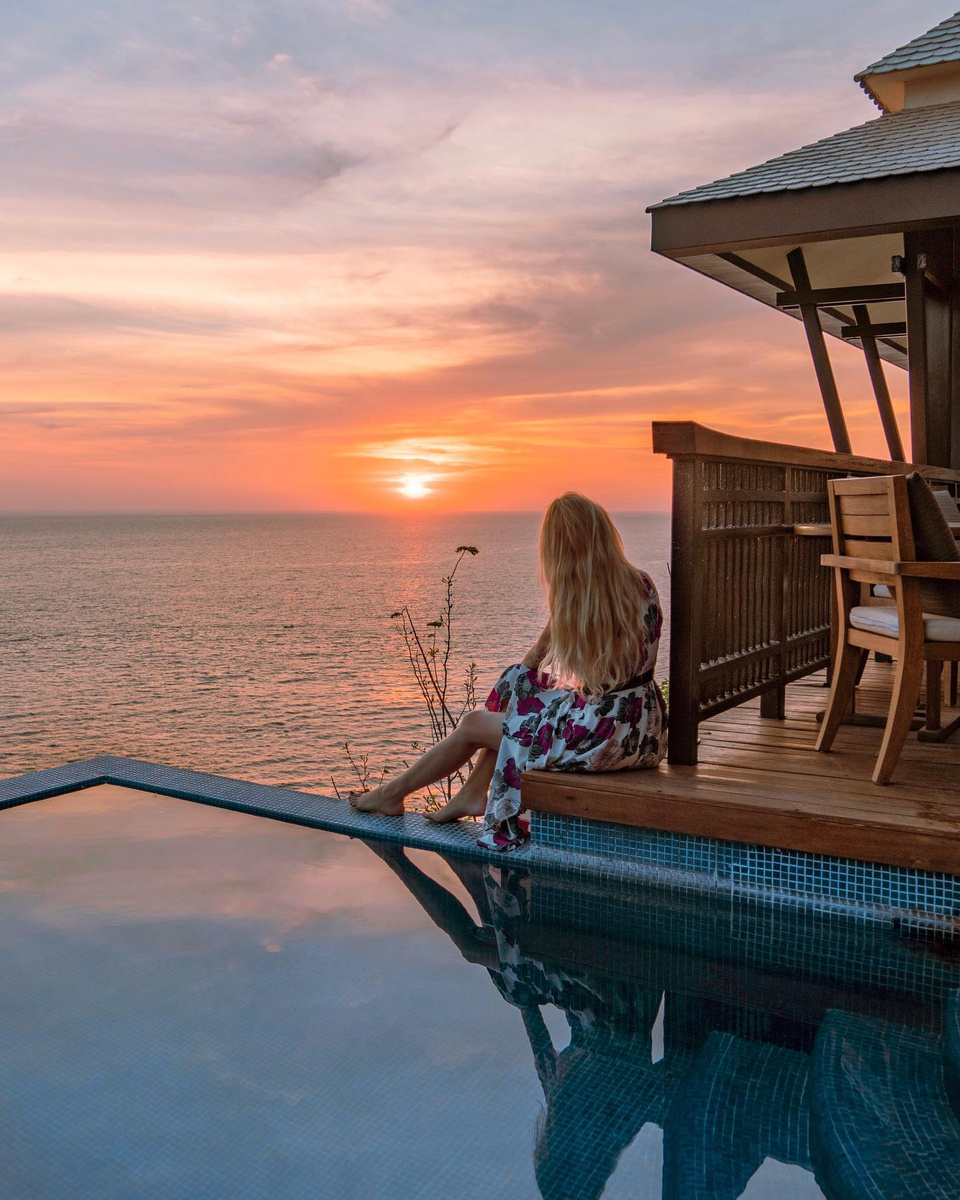 Olga seated beside an infinity pool overlooking an Acapulco sunset.