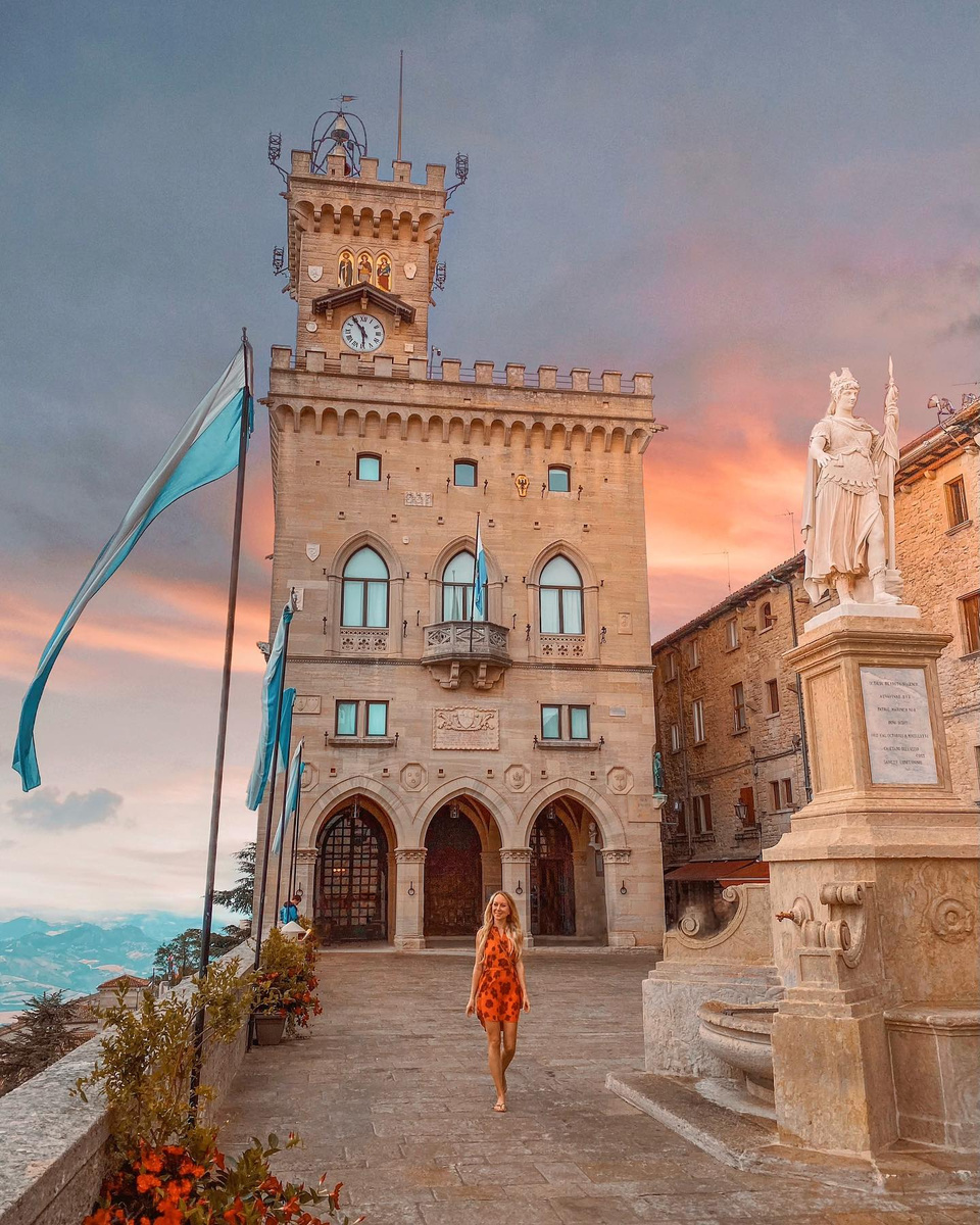 Olga in an orange dress before Palazzo Pubblico in San Marino.