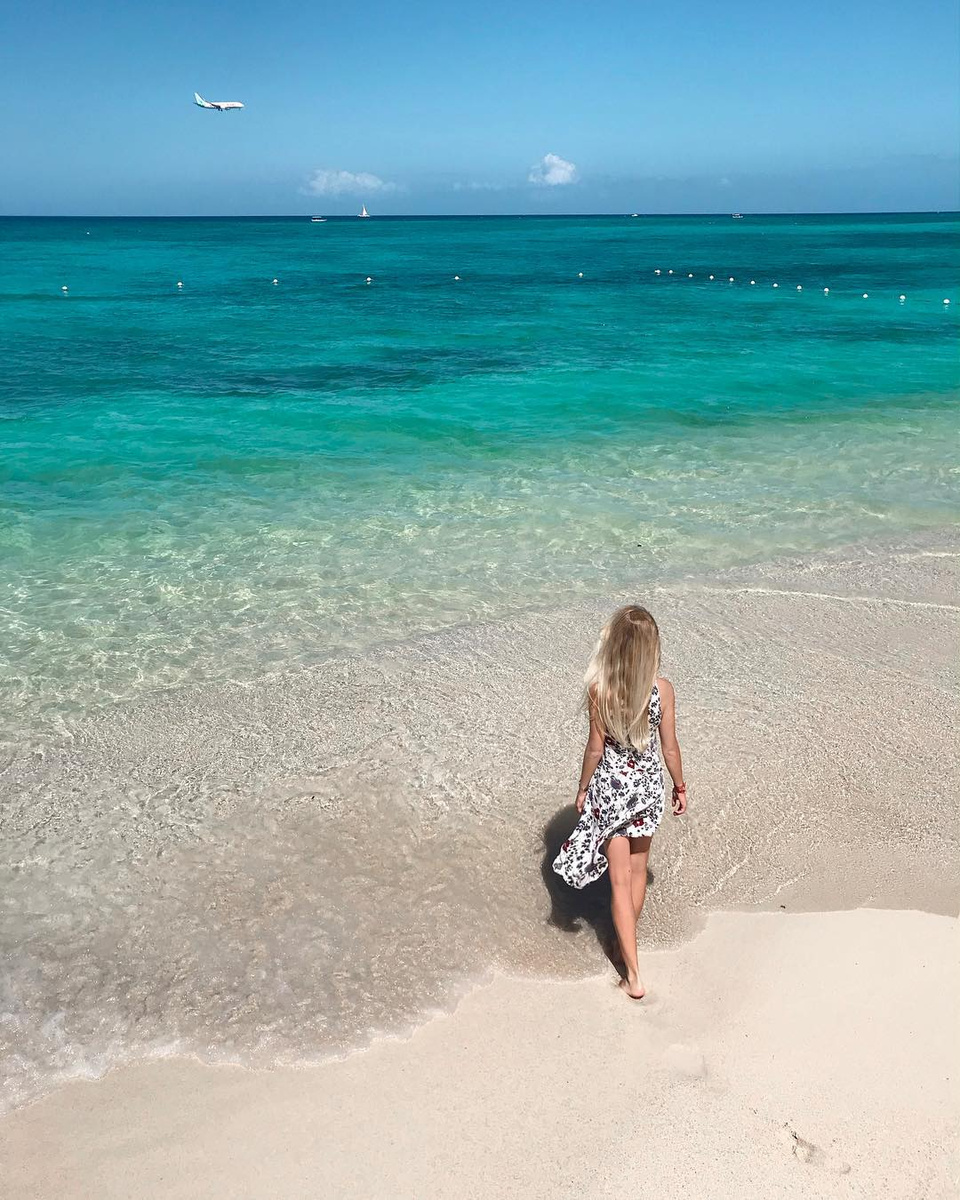 Olga walking into clear turquoise water from a white Jamaican beach.