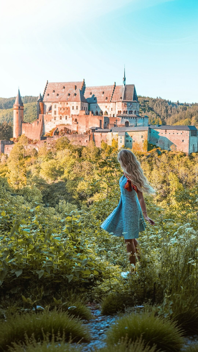Olga before Vianden Castle in the green Luxembourg countryside.