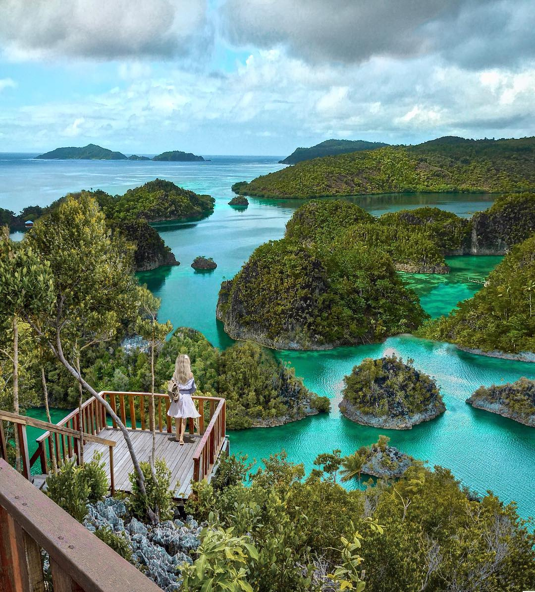 Olga overlooking the turquoise lagoons and forested karst islands of Raja Ampat.