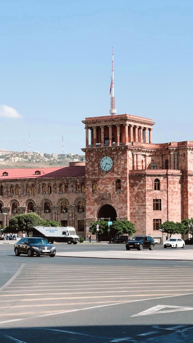 The warm stone buildings and clock tower of Republic Square in Yerevan.