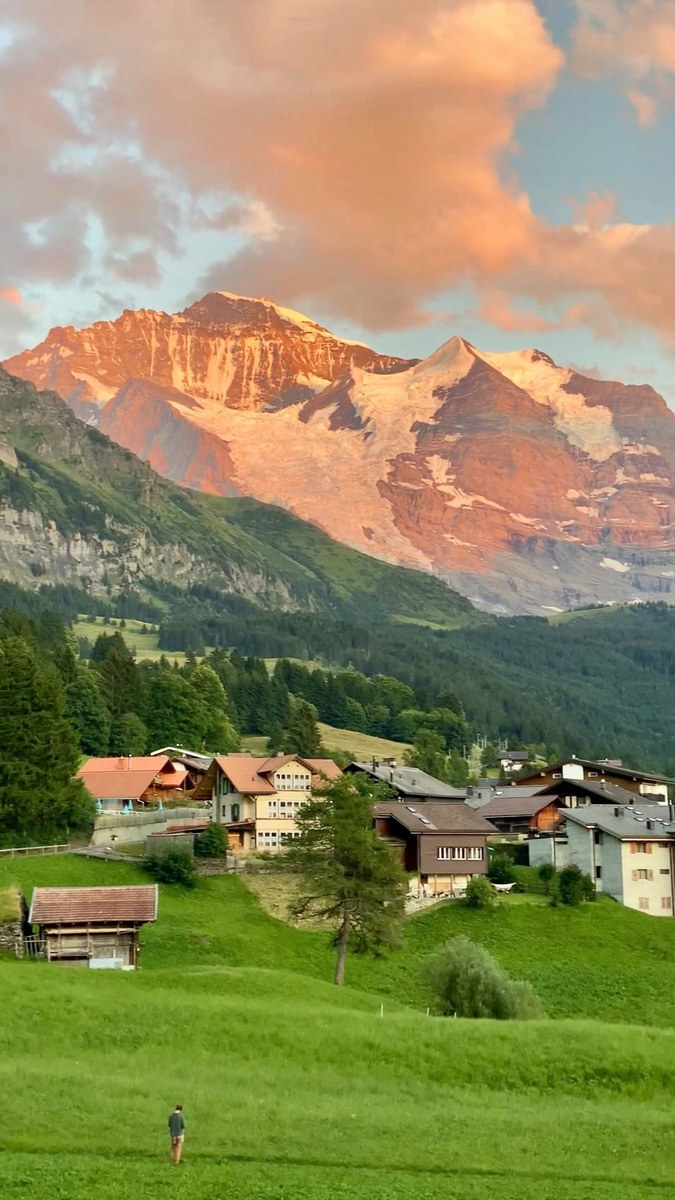 Sunset light on the Jungfrau above a Swiss Alpine village.
