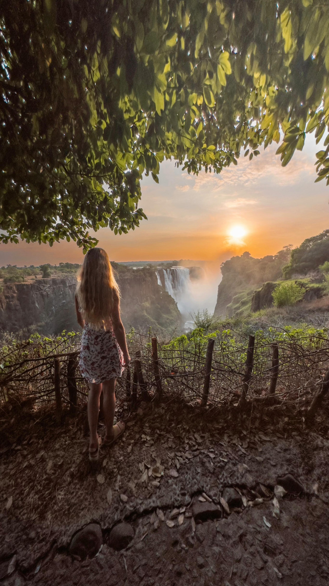 Olga watching sunrise mist rise above Victoria Falls in Zimbabwe.