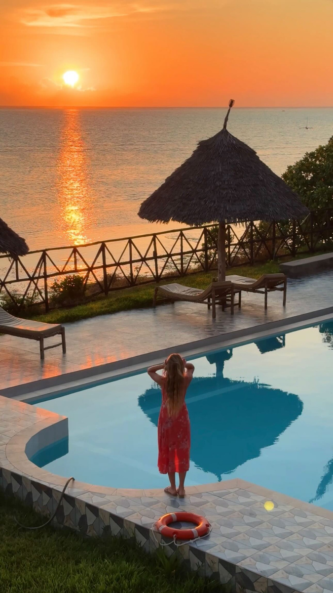 Olga standing beside a pool at sunset on Zanzibar.
