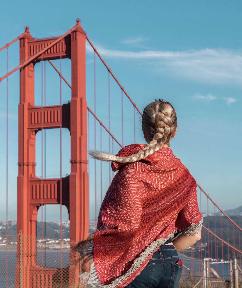 Olga wrapped in a red shawl with the Golden Gate Bridge behind her.