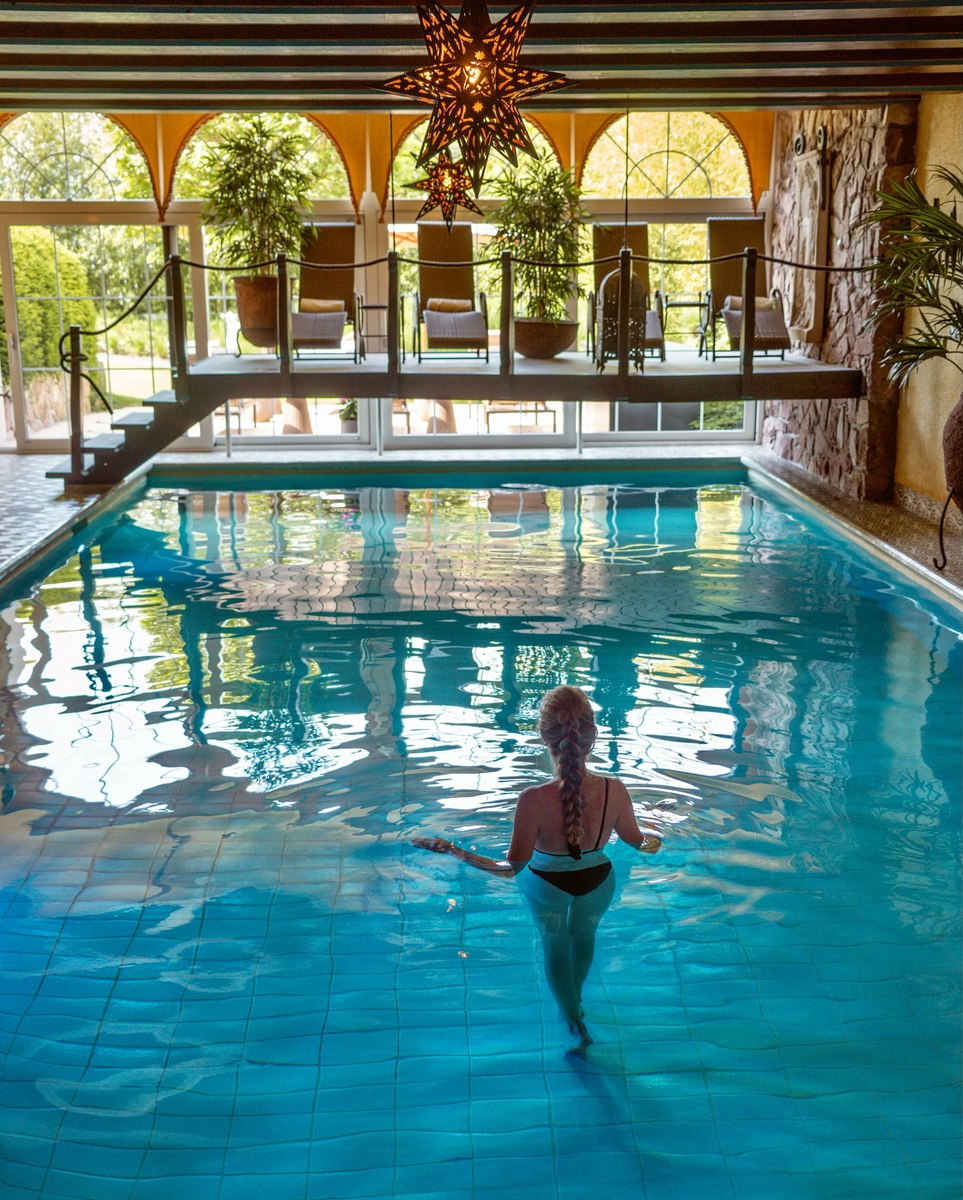 An indoor pool beneath arched windows at Park Hotel Sonnenhof in Liechtenstein.