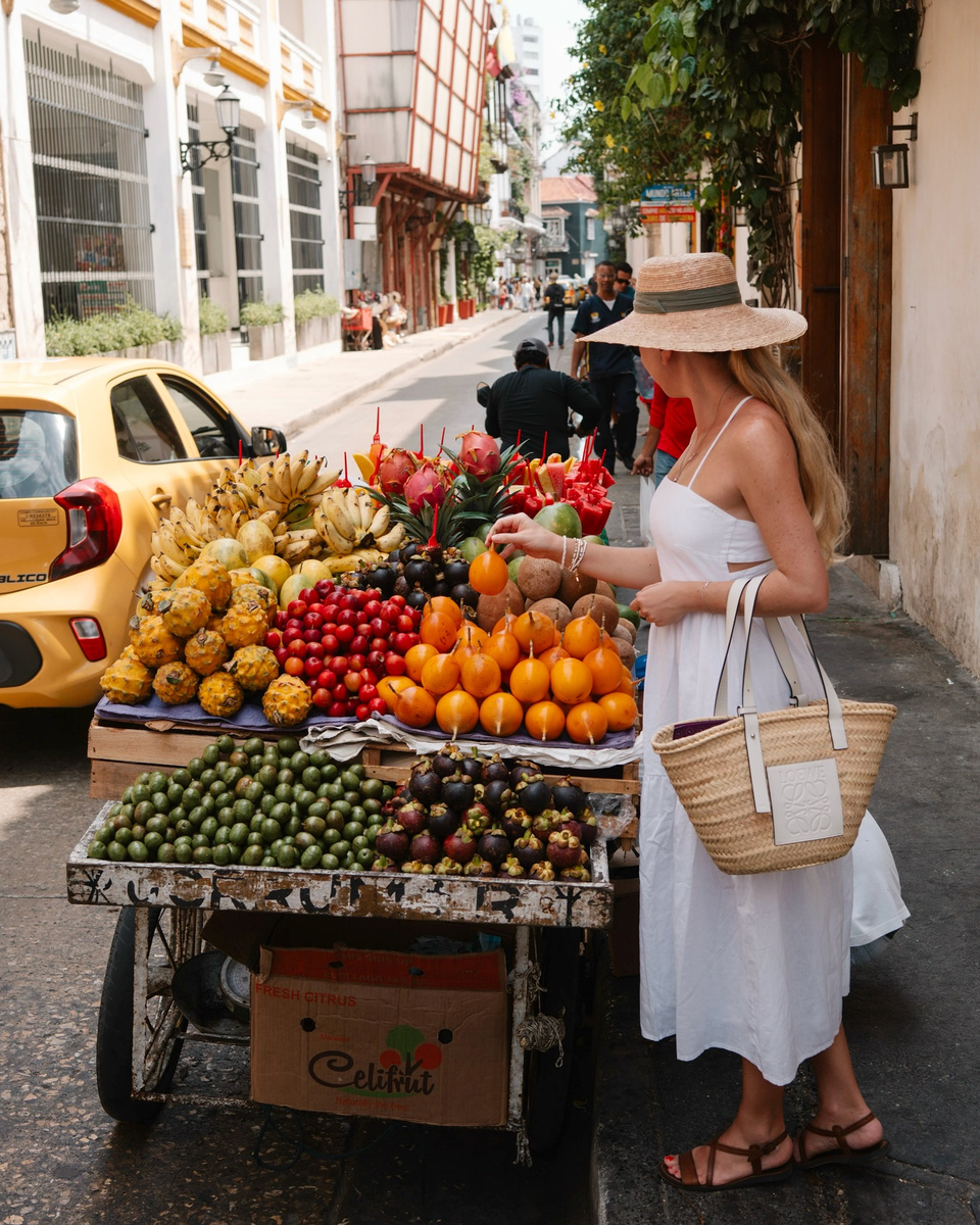 Olga choosing fruit at a colourful street stall in Cartagena.