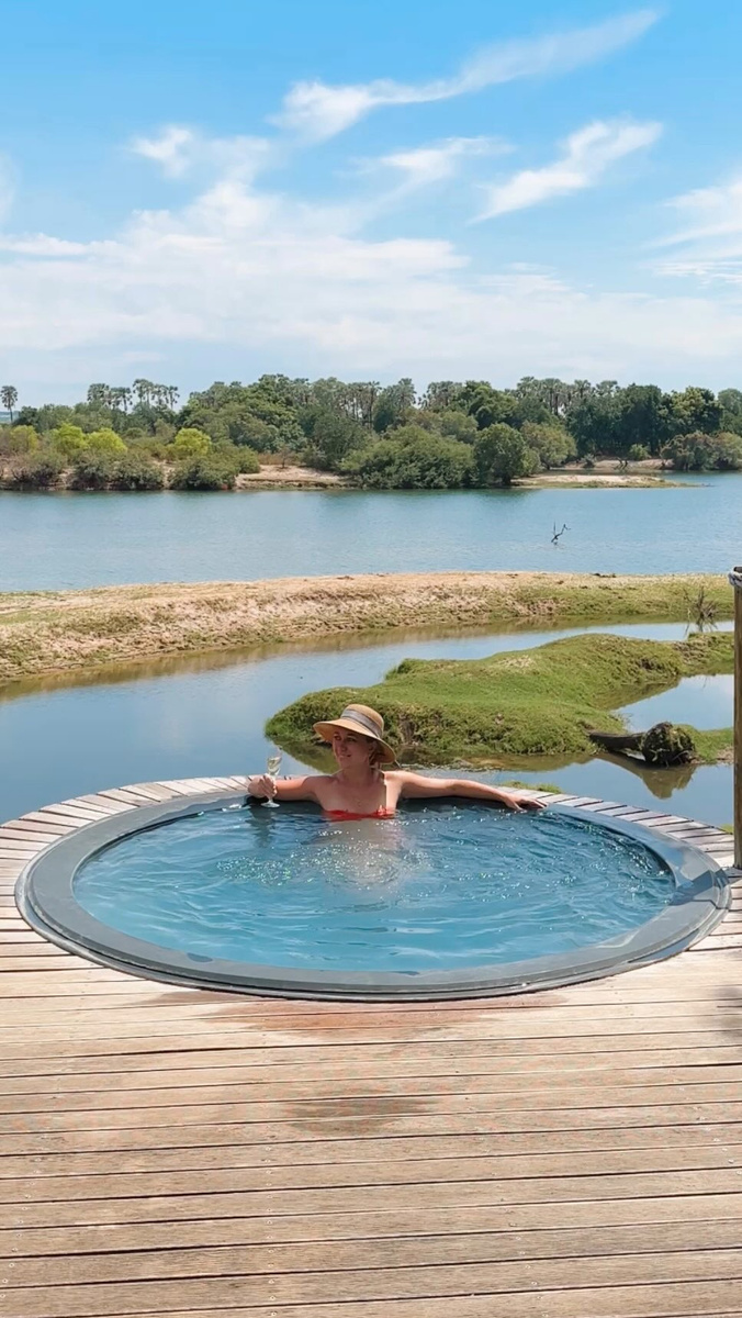 Olga in a round plunge pool overlooking the Zambezi landscape.