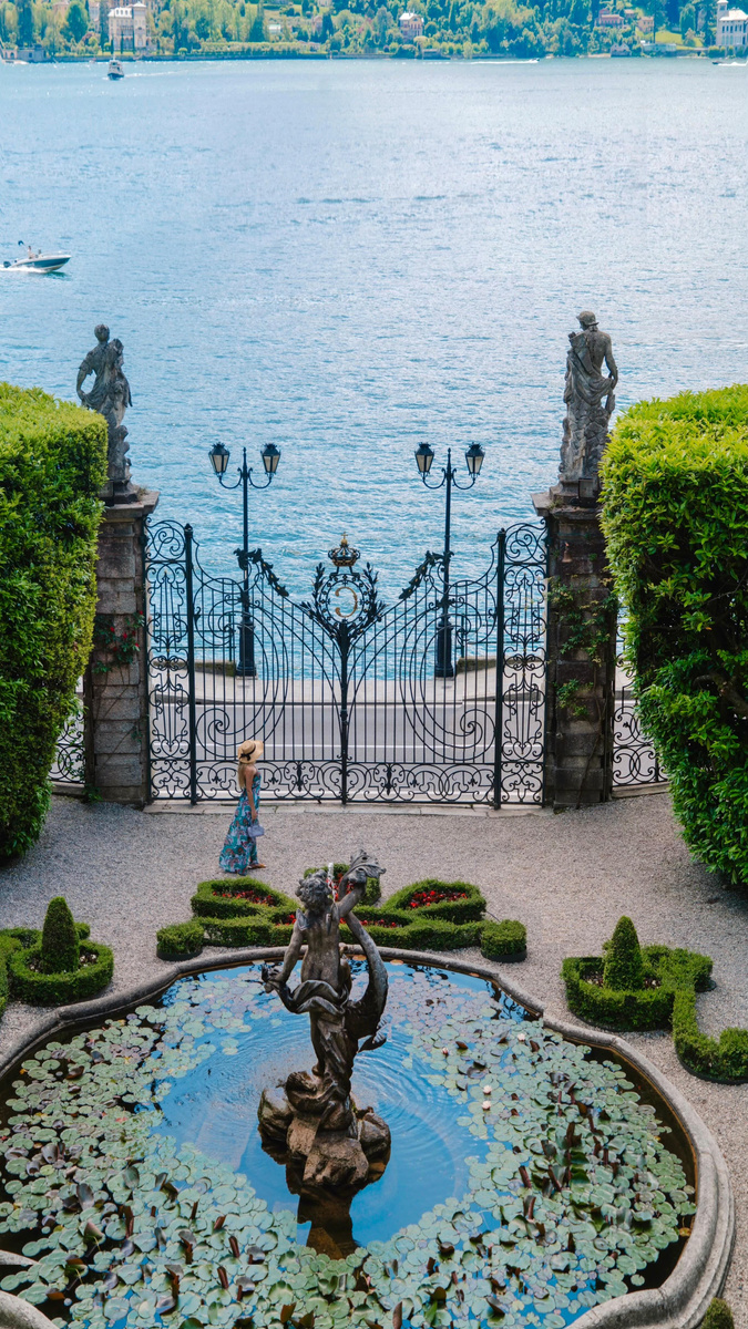 An ornate garden gate framing Lake Como and the mountains beyond.