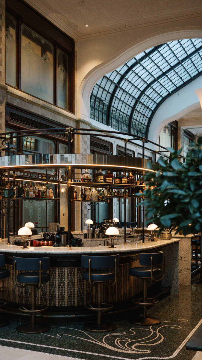 The circular MÚZSA bar glows beneath a glass Art Nouveau arch in Gresham Palace.