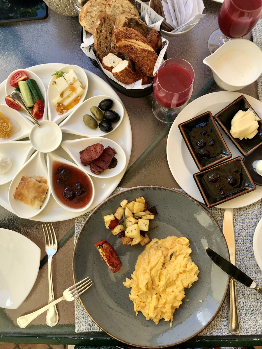 A Turkish breakfast table at Four Seasons Sultanahmet with eggs, cheese, olives, vegetables, honey, preserves and breads.