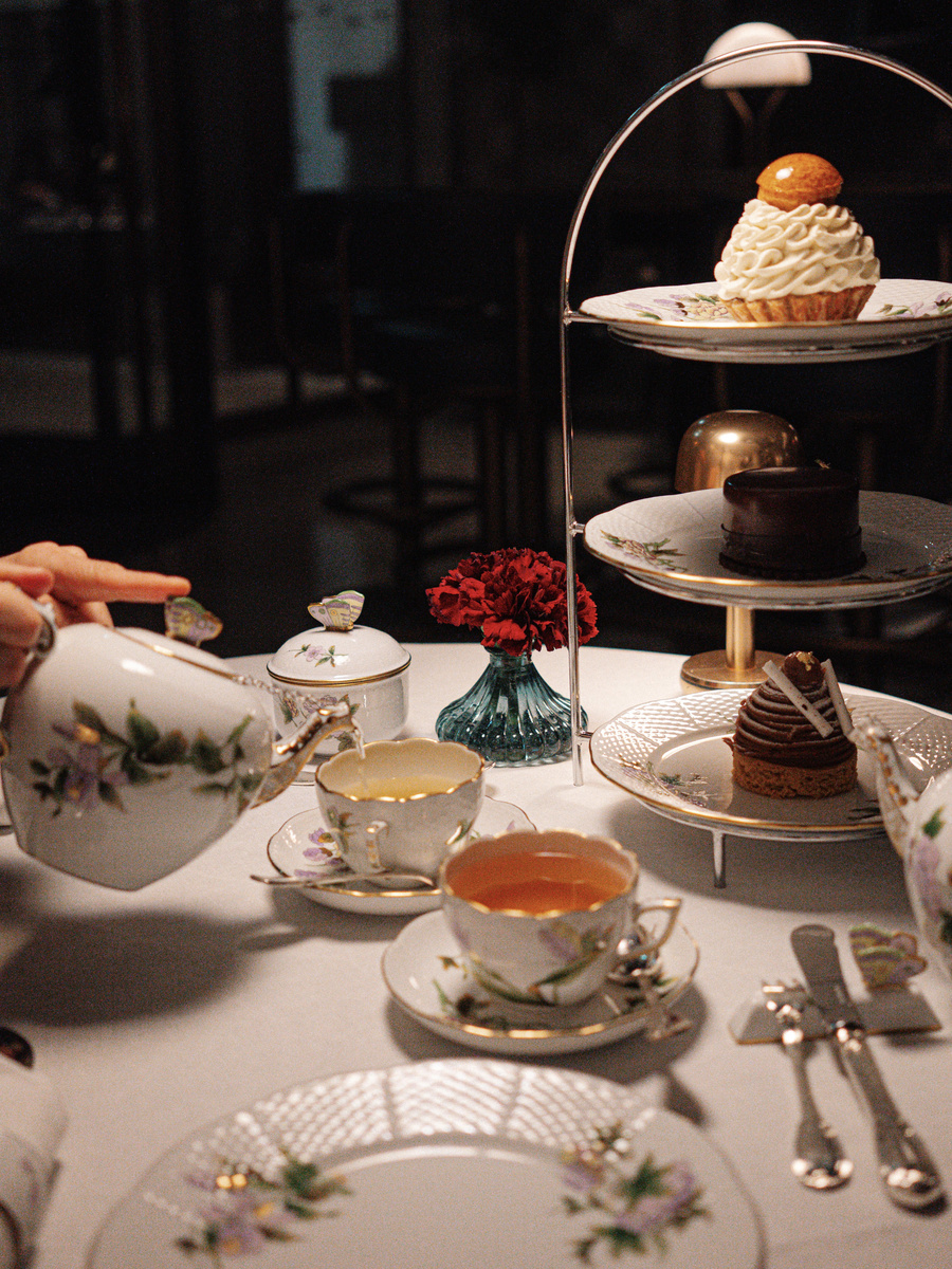 Afternoon tea with pastries is served on floral china at MÚZSA.