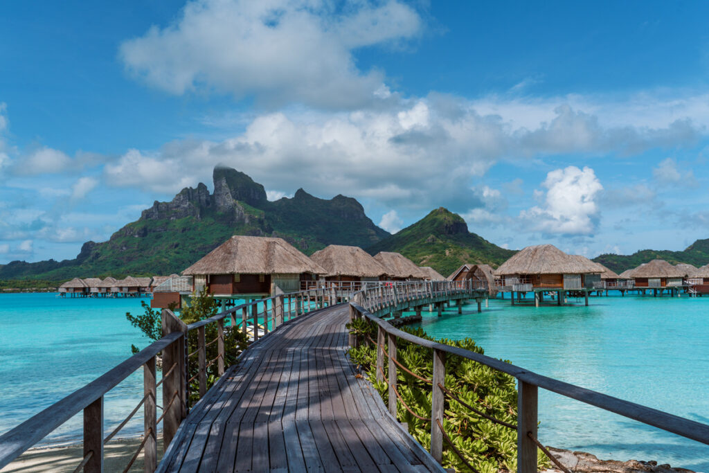 Overwater bungalows lining a turquoise lagoon beneath Mount Otemanu at Four Seasons Bora Bora