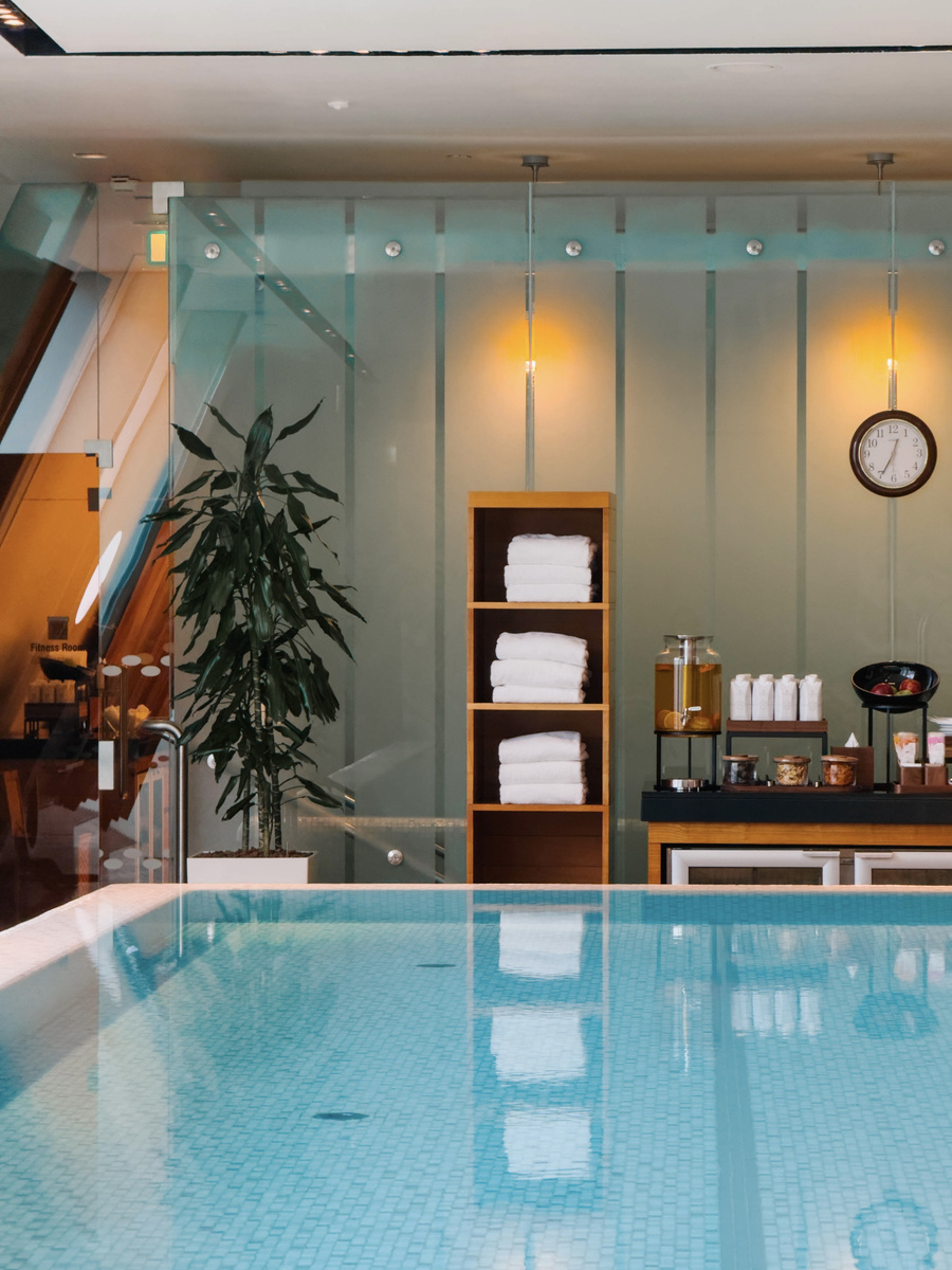 The quiet indoor pool at Four Seasons Gresham Palace reflects pale green walls and warm lights.
