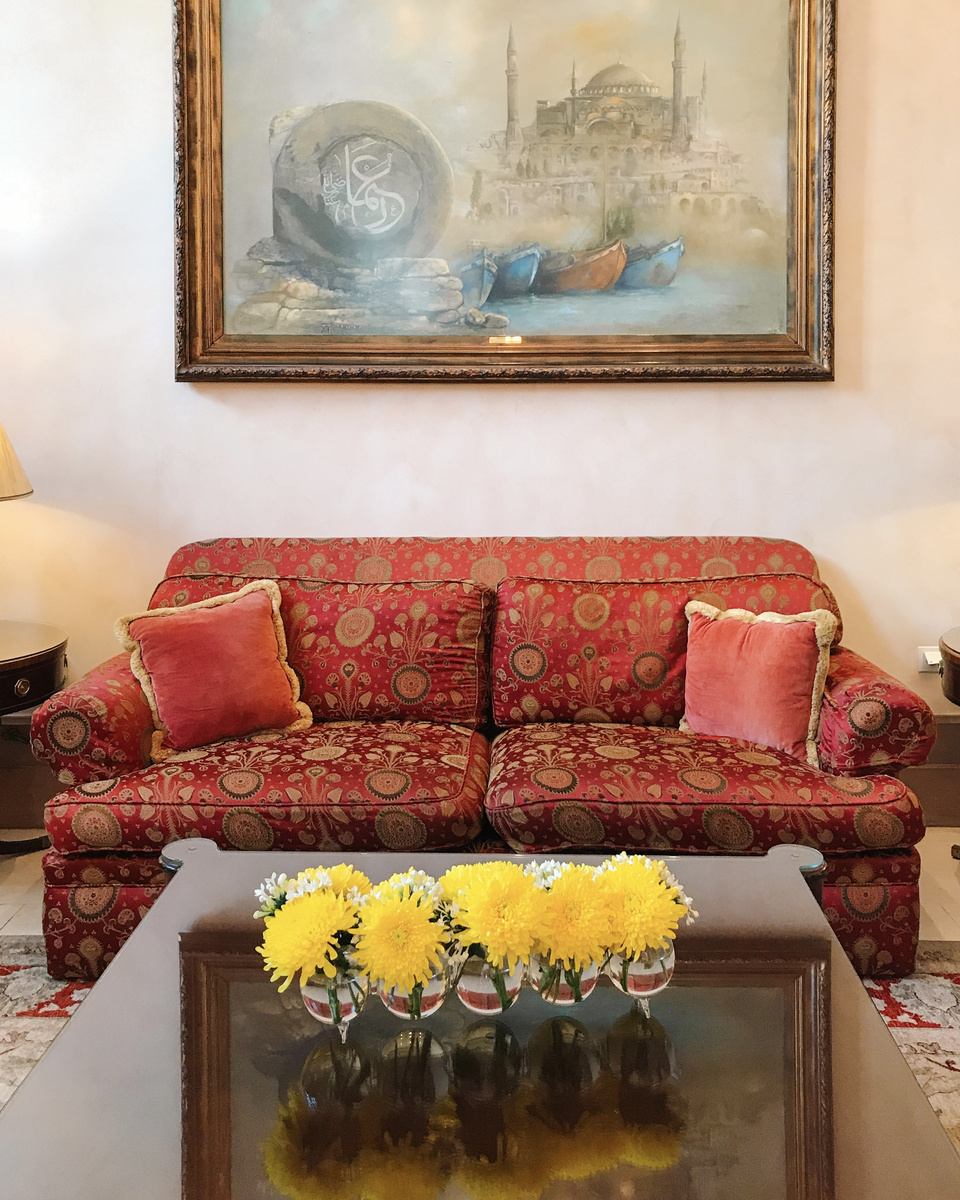 A red patterned sofa, yellow flowers and a painting of Hagia Sophia in the 2018 Four Seasons Sultanahmet interior.