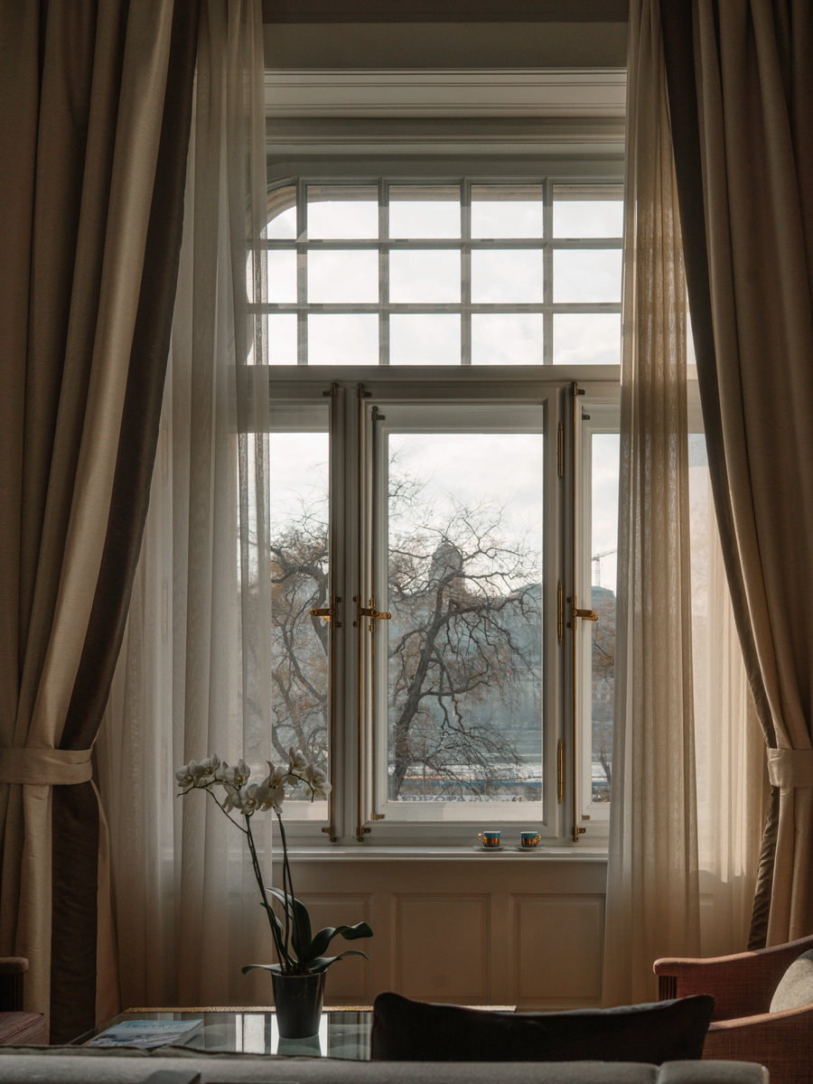 A tall guest-room window at Four Seasons Gresham Palace opens towards the Danube and Buda.