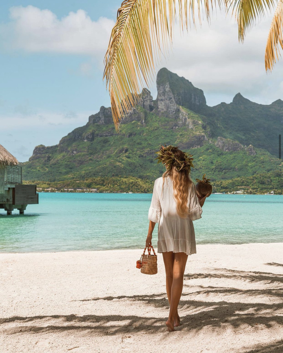 Olga walking along the beach with the lagoon and Mount Otemanu ahead at Four Seasons Bora Bora