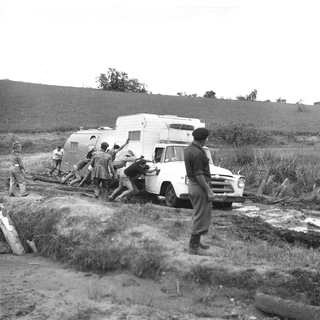 Caravanners push a tow vehicle and Airstream trailer through deep mud during the Cape Town–Cairo journey.