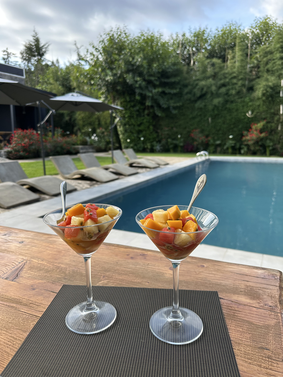 A tray of fresh fruit and drinks rests beside Amarembo’s swimming pool and flower garden.