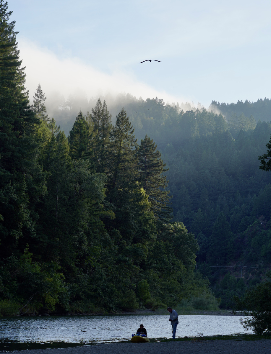 Mist lifting above the Russian River with dark forested hills beyond