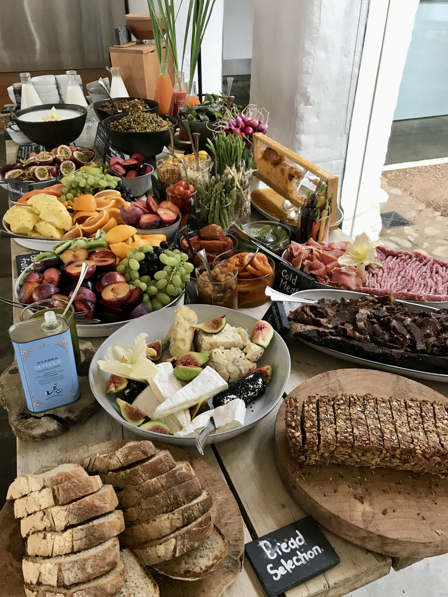 Bread, cheese, fruit, vegetables and charcuterie fill a Babylonstoren breakfast table.