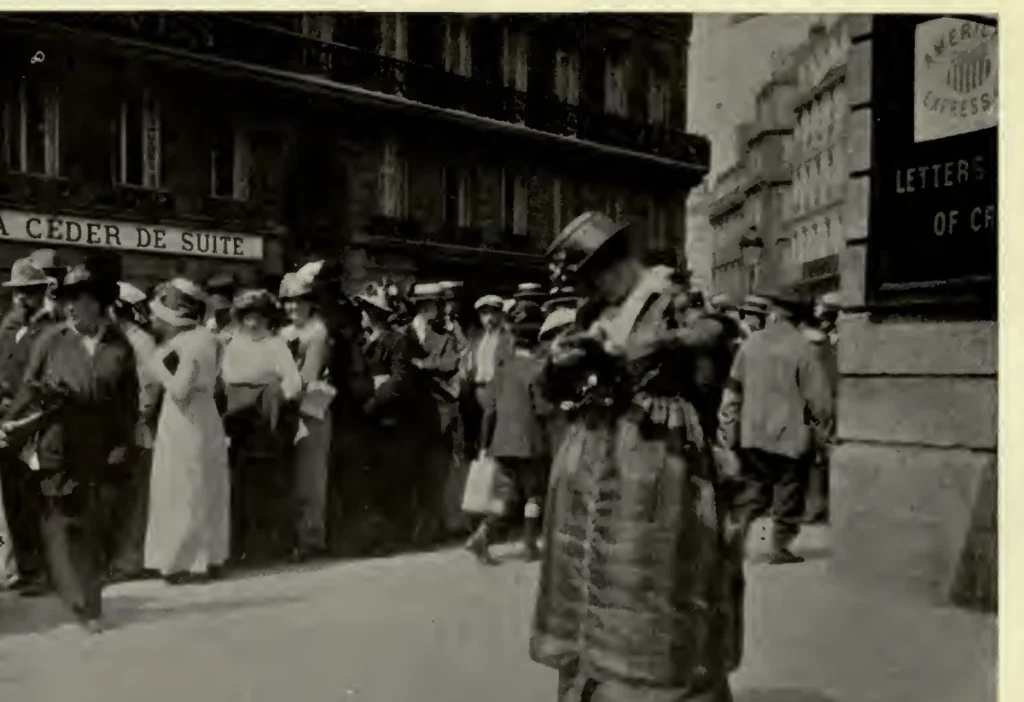 Crowd of American travellers outside the American Express office in Paris in August 1914, gathered beneath the company sign to obtain money.