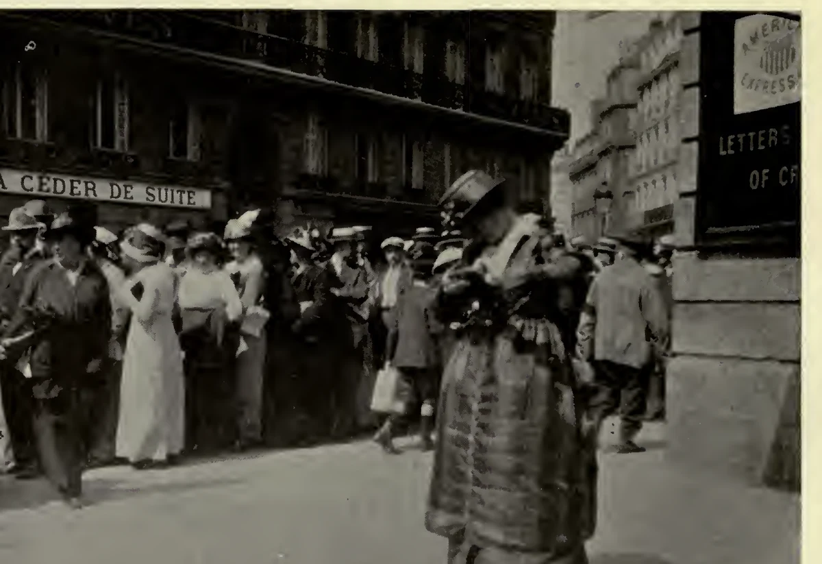 Crowd of American travellers outside the American Express office in Paris in August 1914, gathered beneath the company sign to obtain money.