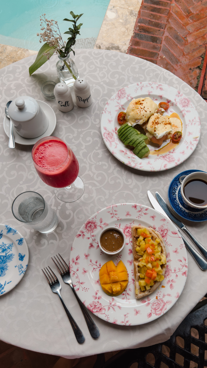 Eggs, avocado, mango, juice and coffee are arranged on a breakfast table at Casa del Pozo.