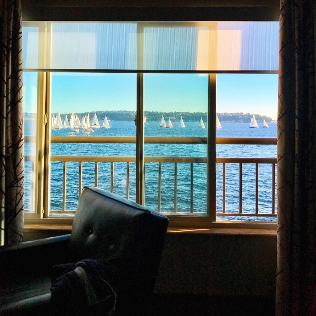 Sailboats cross Elliott Bay beyond an open window at The Edgewater Hotel in Seattle.