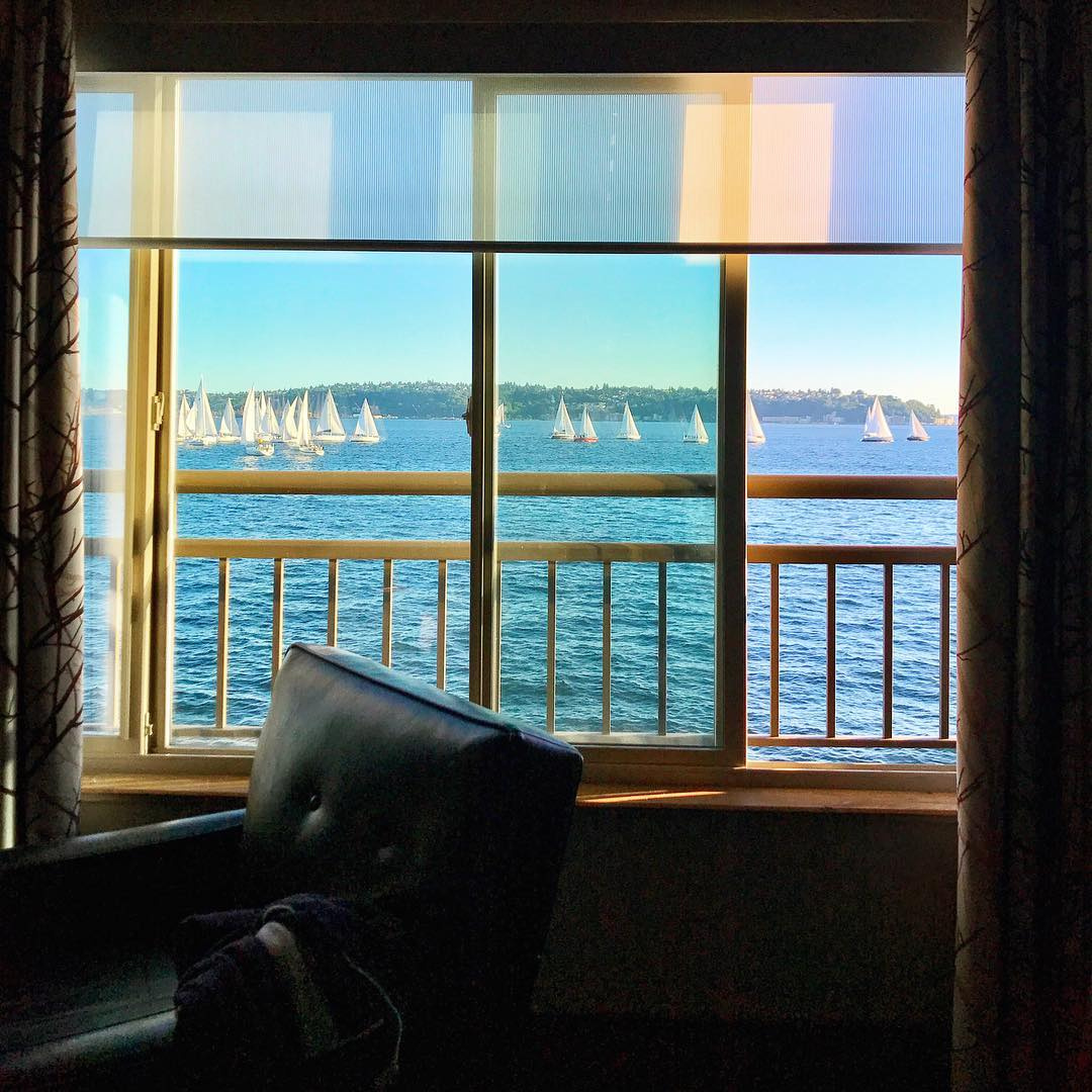 Sailboats cross Elliott Bay beyond an open window at The Edgewater Hotel in Seattle.
