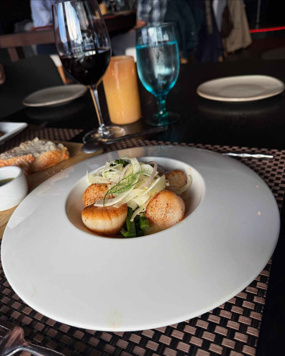 Seared scallops with fennel and green vegetables are served at Six Seven Restaurant in The Edgewater Hotel.