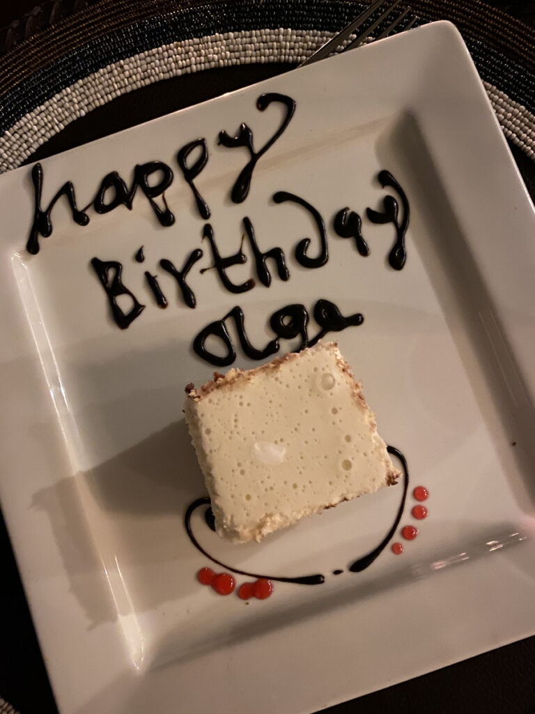 A small dessert on a plate decorated with the words Happy Birthday Olga at Entim Camp.