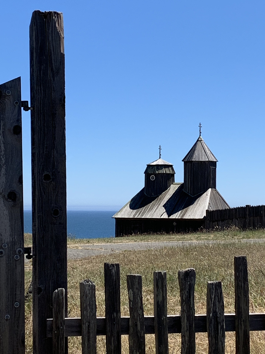 Wooden chapel and palisade at Fort Ross seen through the open stockade gate