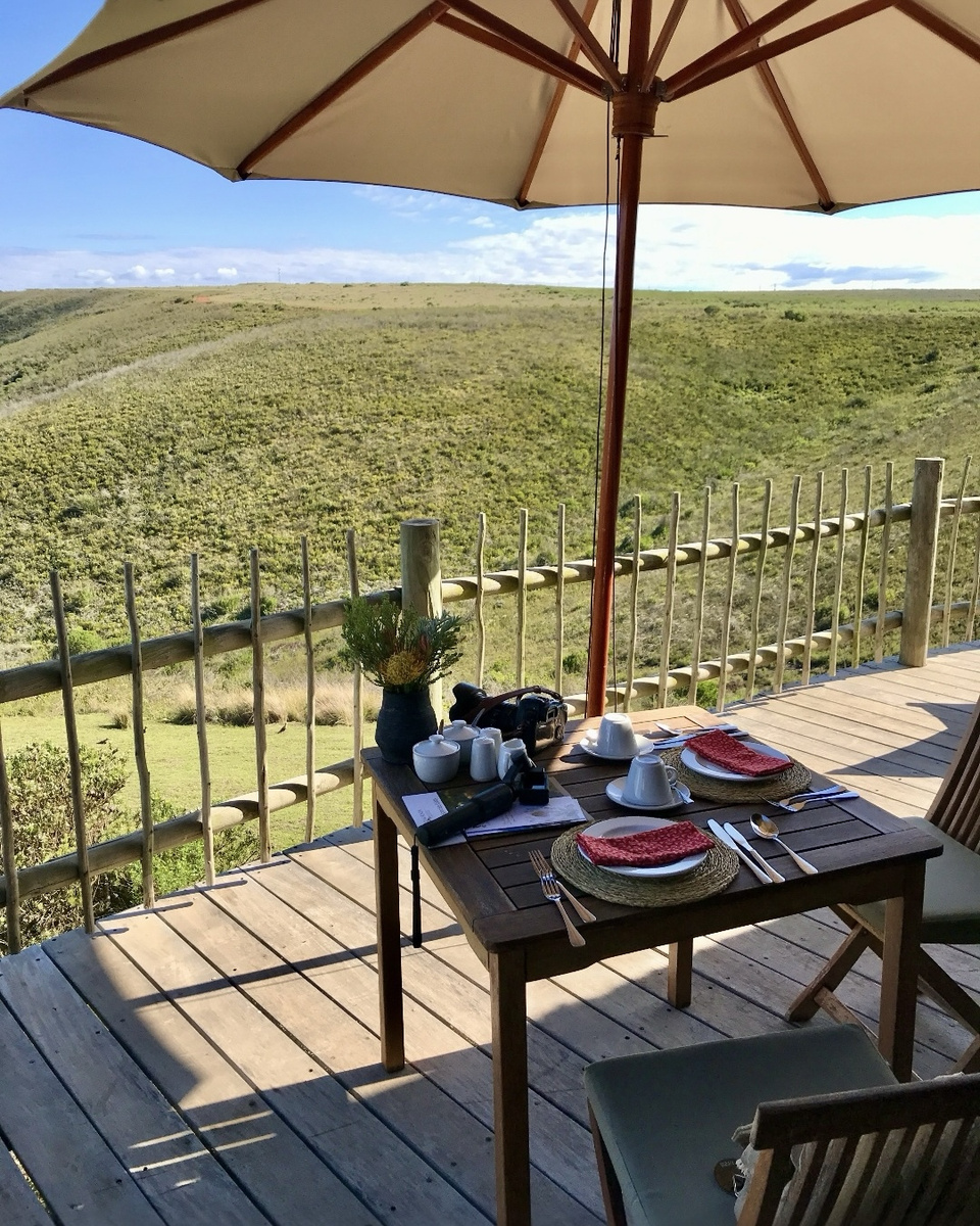 Breakfast laid on a table on a villa veranda overlooking Gondwana Game Reserve