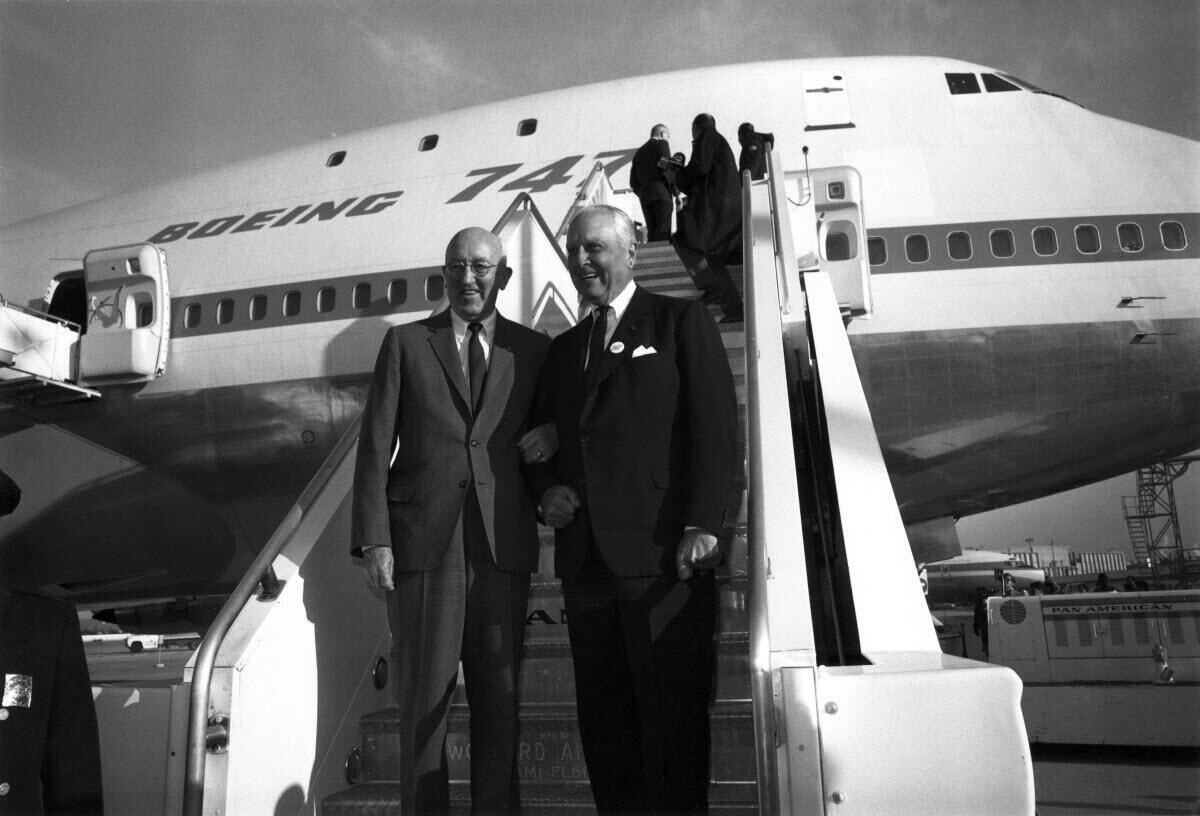Juan Trippe and Boeing president William Allen stand at the foot of stairs beside a Boeing 747.
