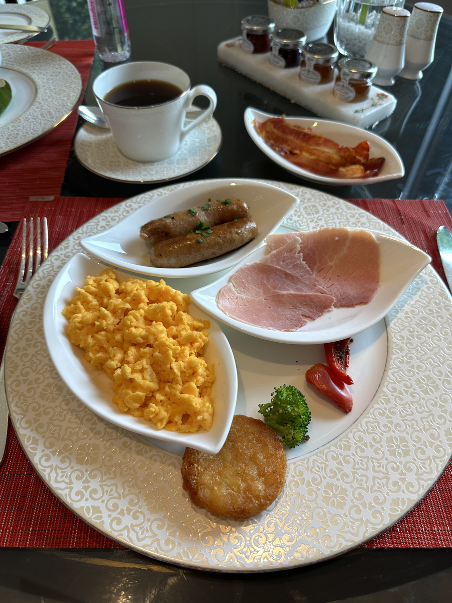 Scrambled eggs, ham, sausages, bacon and a potato cake at breakfast at The Oberoi Amarvilas.