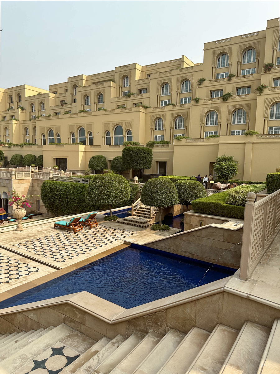 The guest-room wing rises above geometric gardens and blue pools at The Oberoi Amarvilas.
