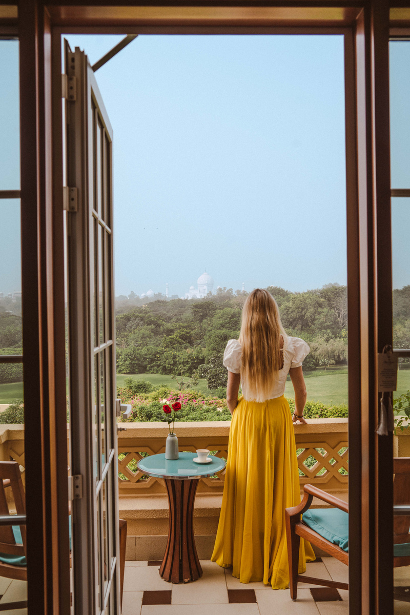 Olga stands on her balcony at The Oberoi Amarvilas, looking toward the Taj Mahal beyond the gardens.