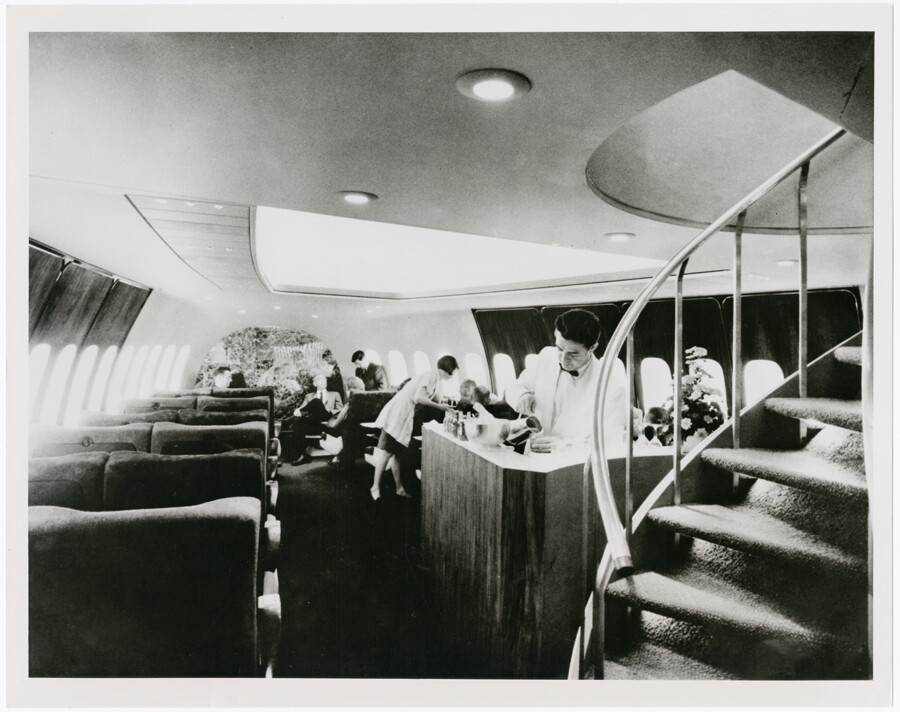 Pan Am’s Boeing 747 first-class cabin with a bar and spiral staircase leading to the upper deck.