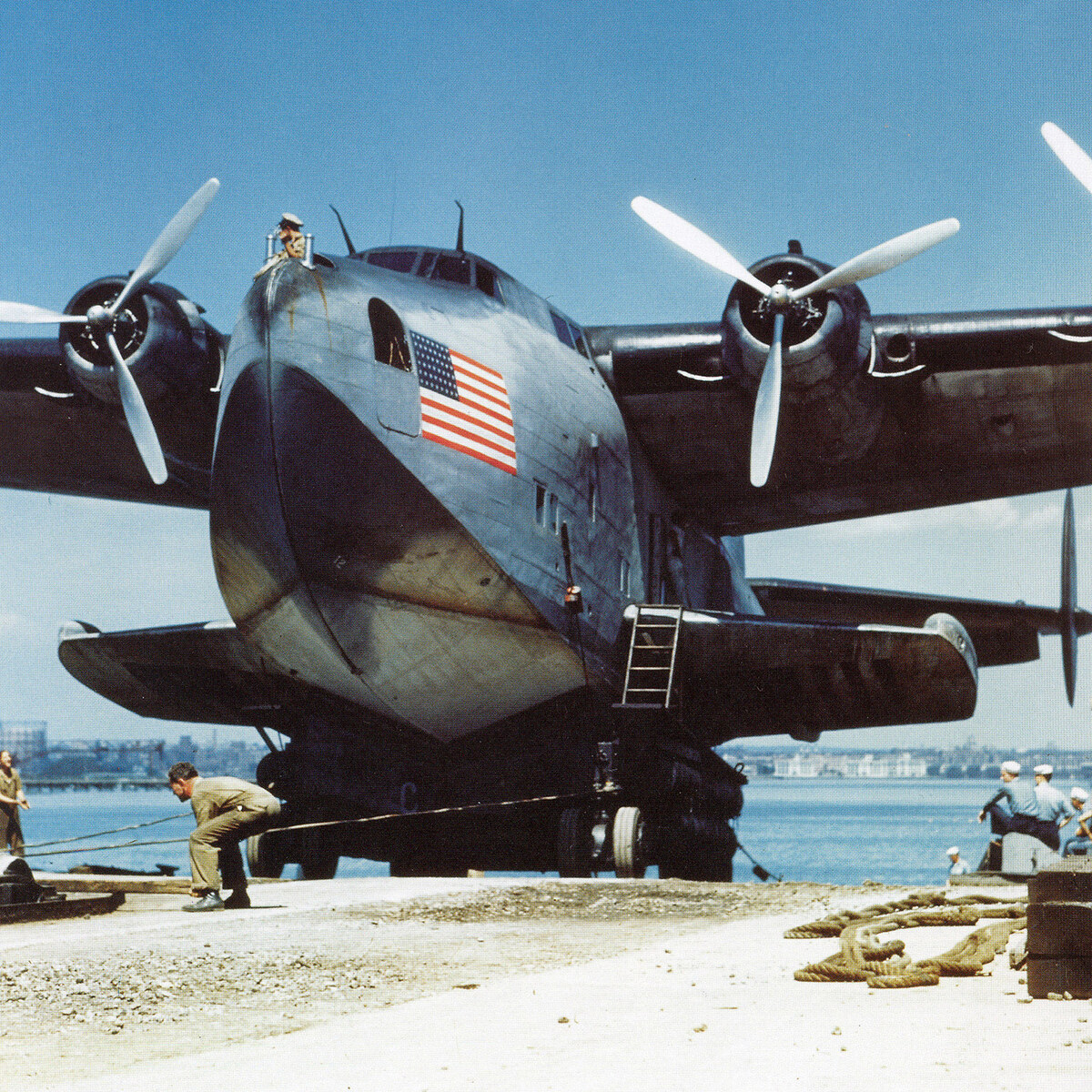 Rare colour photograph of ground crews servicing a Pan American Boeing 314 flying boat beside the water in the late 1930s.