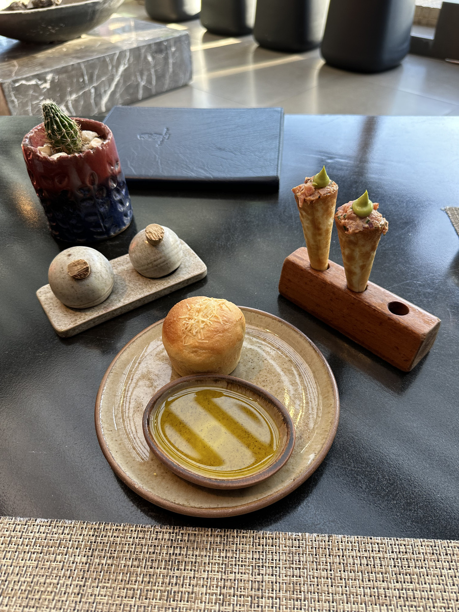 Bread, olive oil, small savoury cones and two covered bites begin dinner at Estró in The Ritz-Carlton Santiago.