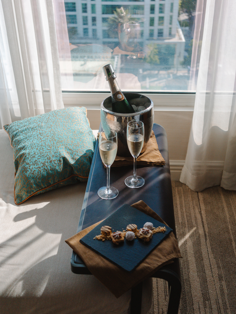 Champagne, two glasses and small welcome treats sit on a table in a guest room at The Ritz-Carlton Santiago.