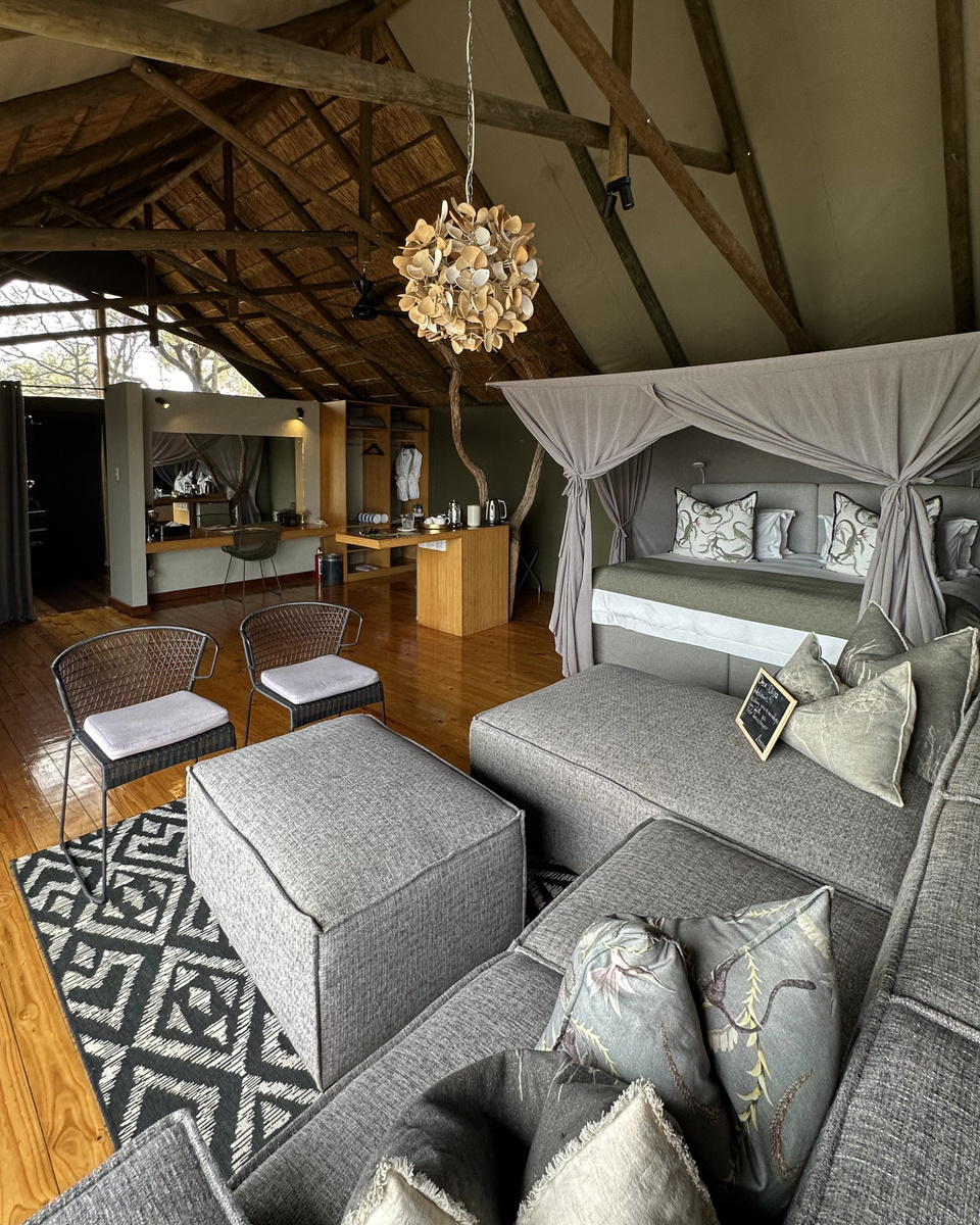 A broad view of Olga’s tented suite shows the canopy bed, sitting area, polished timber floor and open bathroom.