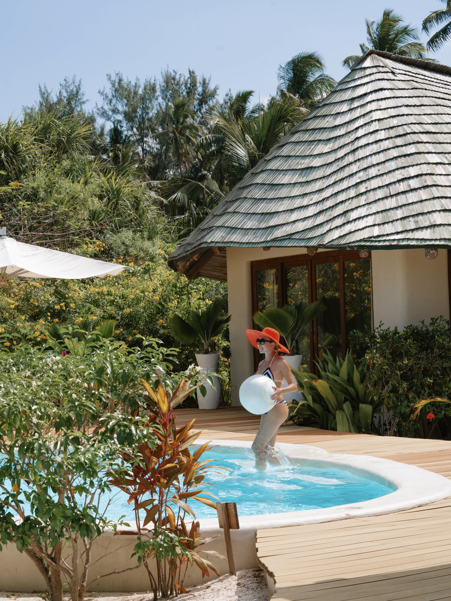 Olga steps into the private pool beside her thatched beachfront villa.