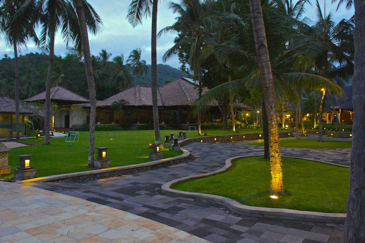 Palm-lined paths between lawns and villas at The Santosa Villas & Resort.
