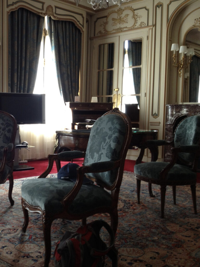 Upholstered chairs, mirrored doors and a writing desk in our room at Hôtel Raphael.