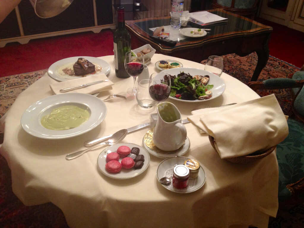 Room-service dinner laid on a white tablecloth in our room at Hôtel Raphael.